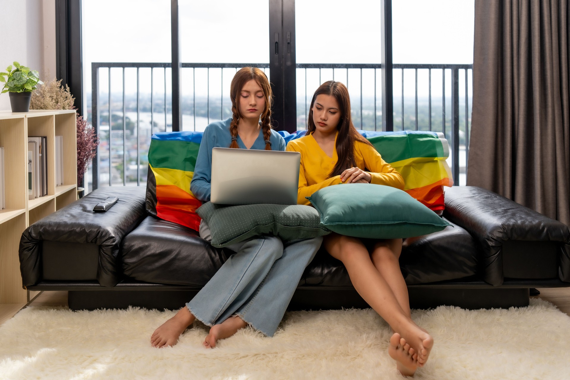 CouplesTwo women sitting on couch, working on laptop, relaxed atmosphere. The concept of gender identity is very diverse